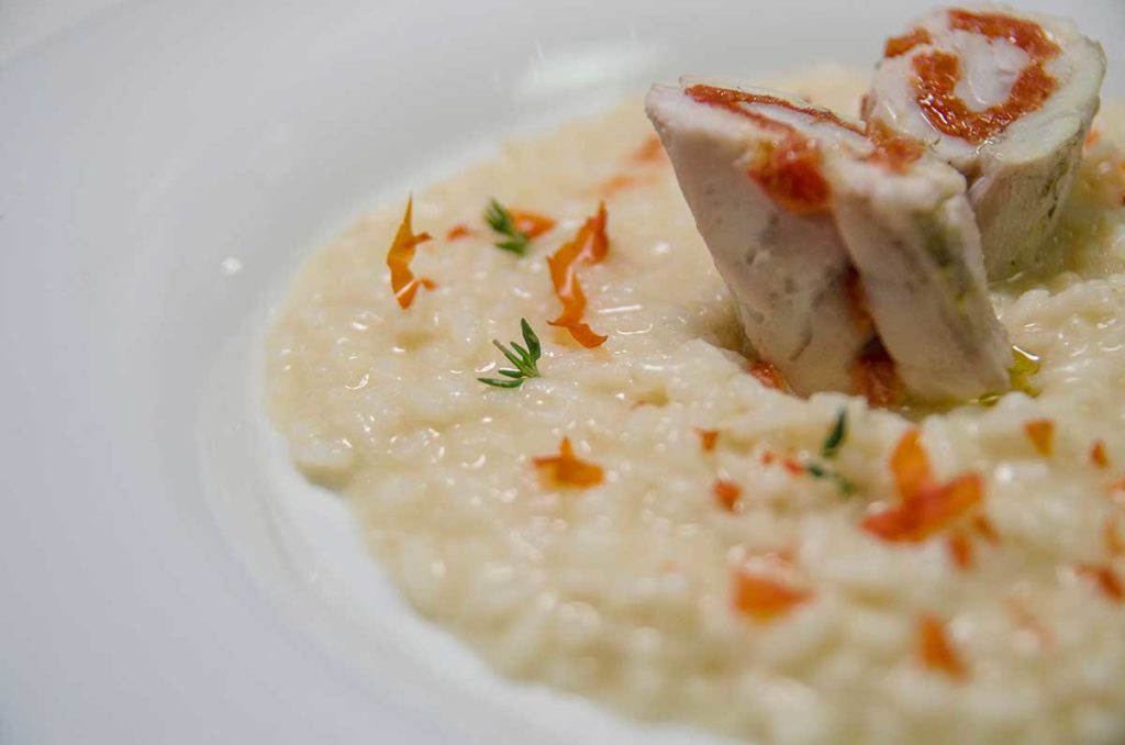 Risotto al brodo di cappone, involtino di spigola e pomodorini confit